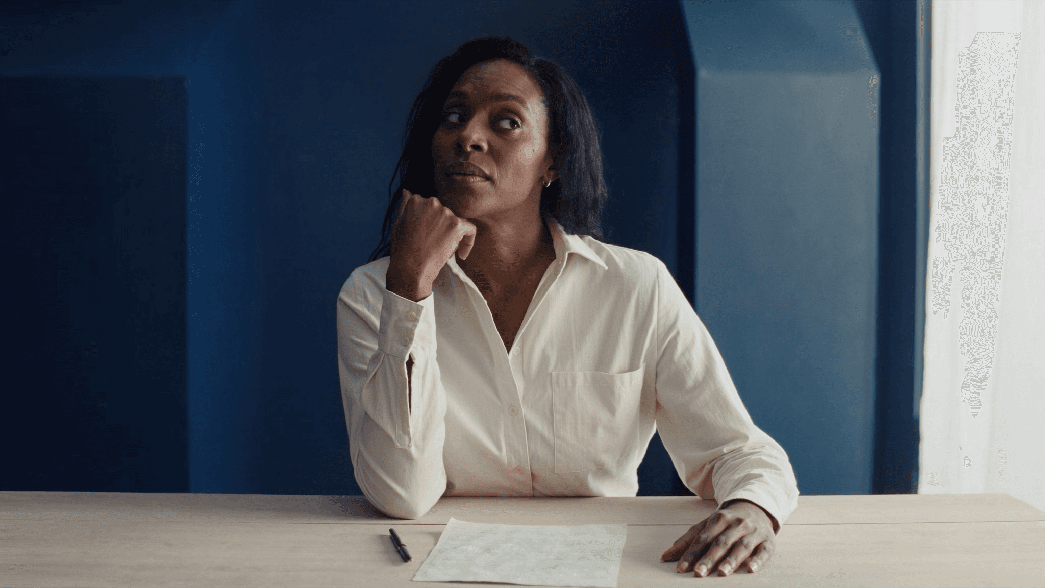 A woman pausing to reflect at a table